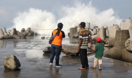 Pengunjung mengamati gelombang tinggi di Pantai Glagah, Kulon Progo, DI Yogyakarta, Jumat (19/4/2019). 