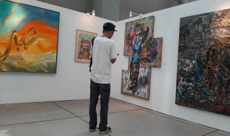 Pengunjung mengamati karya seni di pameran 