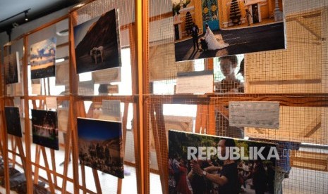 Pengunjung mengamati pameran foto Everything In Between:The Exhibition di Kopi Kalyan, Jakarta, Selasa (12/3). Pameran ini menyajikan perjalanan bersepeda Diego Yanuar bersama Marlies Fennema dari Belanda ke Indonesia, pameran foto ini akan berlangsung 12-24 Maret 2019.