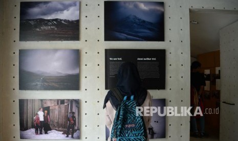 Pengunjung mengamati pameran foto Everything In Between:The Exhibition di Kopi Kalyan, Jakarta, Selasa (12/3). Pameran ini menyajikan perjalanan bersepeda Diego Yanuar bersama Marlies Fennema dari Belanda ke Indonesia, pameran foto ini akan berlangsung 12-24 Maret 2019.