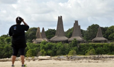 Pengunjung mengamati rumah adat di Kampung Adat Waiyapu, Desa Wainyapu, Kecamatan Kodi Balaghar, Kabupaten Sumba Daya Barat, Nusa Tenggara Timur (NTT), Kamis, (25/2/2016). Puluhan rumah adat di kampung tersebut terbakar pada Selasa (20/9/2022) dini hari. 