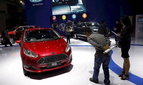 Pengunjung mengamati sedan Ford dalam pameran Indonesia International Motor Show di Jakarta, bulan Augustus tahun 2015.