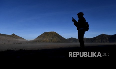 Pengunjung mengambil gambar hamparan pasir yang diselimuti embun upas dengan gawai miliknya di kawasan Gunung Bromo, Probolinggo, Jawa Timur, Ahad 30/6/2019). 