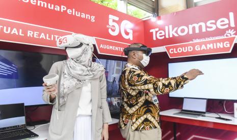 Pengunjung menggunakan peralatan virtual reality di stan Telkomsel saat pameran Gugus Tugas Industri (ITF) pada pertemuan keempat Kelompok Kerja Ekonomi Digital (4th DEWG) Presidensi G20 Indonesia di Nusa Dua, Bali, Rabu (31/8/2022).