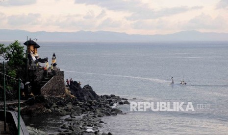 Pengunjung mengunakan sampan menikmati keindahan Pantai Sengigi, Lombok Barat, Nusa Tenggara Barat (NTB) Ahad (13/12).