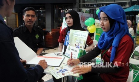 Pengunjung mengunjungi booth peserta dari pameran produk dan jasa keuangan syariah, Keuangan Syariah Fair 2016 di Jakarta, Kamis (3/3).