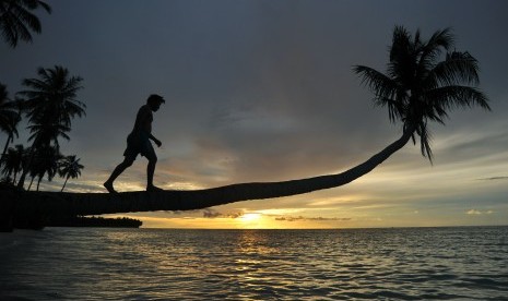 Pengunjung menikmati matahari terbenam di Pantai Mapadegat, Mentawai, Sumatra Barat. 