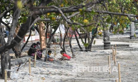 Pengunjung menikmati suasana Pantai Festival Taman Impian Jaya Ancol, Jakarta Utara.