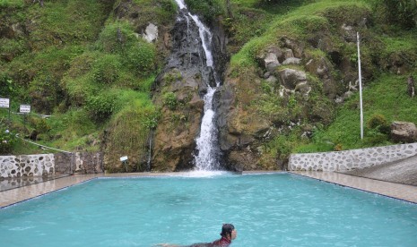 Pengunjung menikmati wisata air terjun yang dirancang dengan kolam renang di desa Parsaoran Sibisa, Kabupaten Toba Samosir, Sumatera Utara, Sabtu (4/5/2019). 