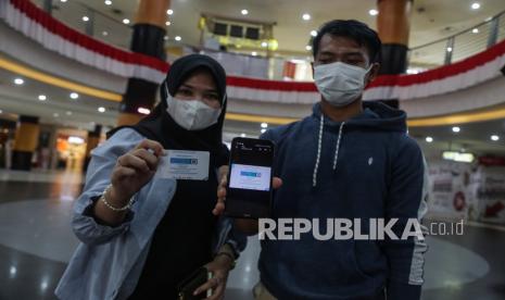 Pengunjung menunjukkan sertifikat vaksin Covid-19 untuk syarat memasuki pusat perbelanjaan di Duta Mall, Banjarmasin, Kalimantan Selatan, Rabu (25/8/2021). Dinkes Banjarmasin mengaku stok vaksin yang tersedia tidak sebanding dengan jumlah warga yang mengantre untuk divaksin.