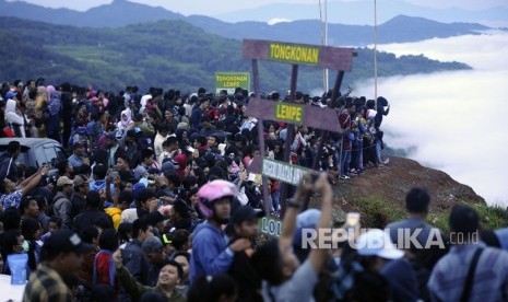 Pengunjung menyaksikan matahari terbit dan kumparan awan dari puncak kampung Lolai, Toraja Utara, Sulawesi Selatan, Kamis (28/12). 