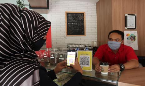 Pengunjung tengah bertransaksi dengan metode pembayaran digital QRIS melalui Mandiri Syariah Mobile di sebauah Coffeeshop di Jakarta.