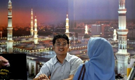 Pengurus biro perjalanan haji dan umroh memberikan keterangan kepada calon jamaah haji di Mihrab Qolbi Travel, Jakarta, Senin (27/7).