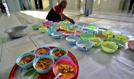 Pengurus masjid mempersiapkan beberapa mangkuk bubur India untuk hidangan berbuka puasa, di Masjid Jami Pekojan Semarang.