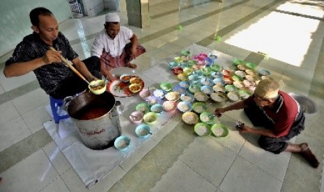 Pengurus masjid mempersiapkan beberapa mangkuk bubur India untuk hidangan berbuka puasa, di Masjid Jami Pekojan Semarang, Senin (30/6).