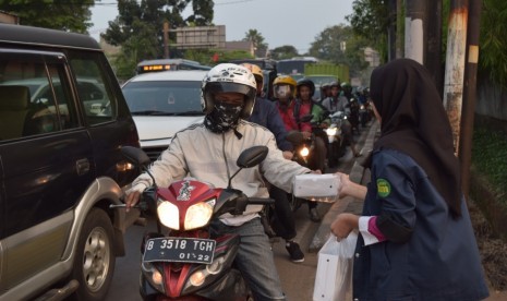 Pengurus OSIS SMP Bakti Mulya 400, Jakart, membagikan takjil gratris kepada pengguna jalan.