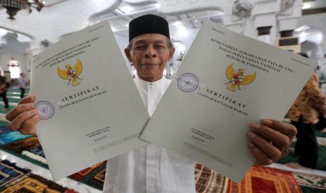 Pengurus salah satu masjid menunjukkan sertifikat tanah wakaf yang diserahkan Wamen ATR Raja Juli Antoni di Masjid Raya Baiturrahman, Banda Aceh, Aceh, Ahad (14/8/2022). 