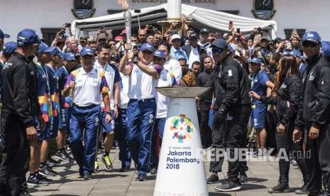 Penjabat Gubernur Jawa Barat M Iriawan (tengah) didampingi Pangdam III Siliwangi Mayjen TNI Besar Harto Karyawan (kedua kiri) dan mantan pebulu tangkis Taufik Hidayat (ketiga kiri) menyalakan mini kaldron saat prosesi Torch Relay Asian Games 2018 di Gedung Sate, Bandung, Jawa Barat, Sabtu (11/8).