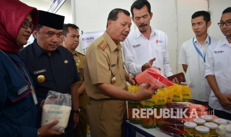 Penjabat Sementara Wali Kota Bandung, Muhamad Solihin (berpeci) dan Sekda Jabar Iwa Karniwa (keempat kanan) meninjau produk yang dijual di Pasar Murah 2018, di Halaman Parkir Stasiun KA Kiaracondong, Kota Bandung, Senin (4/6). 