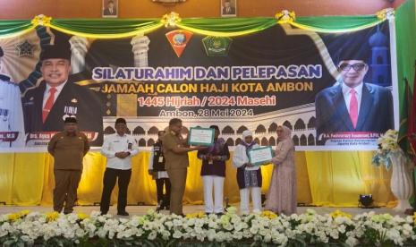 Penjabat Wali Kota Ambon Dominggus Kaya saat menyerahkan tambahan bantuan uang saku kepada perwakilan calon jamaah haji Kota Ambon saat pelepasan di Ambon, Selasa (28/5/2024). 