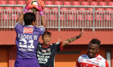  Penjaga gawang Bali United (BU) FC Kadek W (kiri) menangkap bola dibayangi pesepak bola Madura United (MU) FC Guy Junior (kanan) saat pertandingan Liga 1 di stadion Gelora Pamelingan (SGRP) Pamekasan, Jawa Timur, Ahad (16/4).