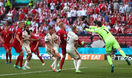 Penjaga gawang Belgia Thibaut Courtois (kanan) membersihkan bola selama pertandingan sepak bola babak penyisihan grup B UEFA EURO 2020 antara Denmark dan Belgia di Kopenhagen, Denmark, 17 Juni 2021. 