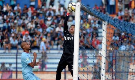 Penjaga gawang Bhayangkara FC Awan Seto (kanan) berusaha mengamankan bola dari pesepak bola Persela Lamongan Loris Arnaud (kiri) dalam lanjutan Liga-1 Indonesia di Stadion Surajaya Lamongan, Jawa Timur, Minggu (16/9).