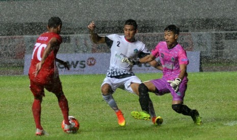 Penjaga gawang dan pemain bertahan provinsi Bali I Putu Gede Bambang Aribawa (kanan) dan I Putu Gede Juni Antara (tengah) berusaha menghalau bola dari serangan pesepak bola DKI Jakarta Rafid Chadafi Lestaluhu (kiri) pada laga grup A cabor sepak bola PON XI