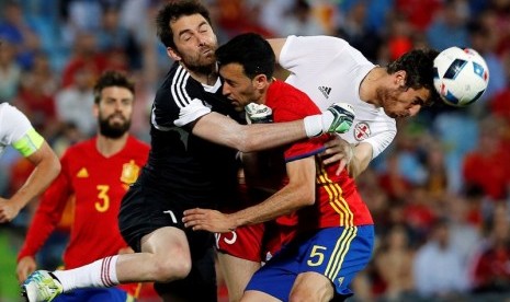 Penjaga gawang Georgia Nukri Revishvili bertabrakan dengan gelandang Spanyol Sergio Busquets.