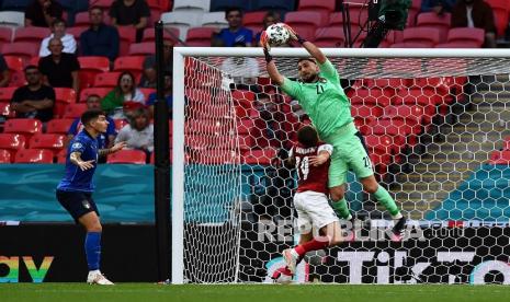 Penjaga gawang Italia Gianluigi Donnarumma, kanan, menangkap bola di bawah tekanan dari pemain Austria Christoph Baumgartner pada pertandingan babak 16 besar Piala Eropa 2020 antara Italia dan Austria di stadion Wembley di London di London, Ahad (27/6) dini hari WIB.