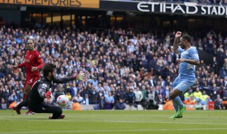 Penjaga gawang Liverpool Alisson, kiri, melakukan penyelamatan di depan pemain Manchester City Raheem Sterling selama pertandingan sepak bola Liga Inggris antara Manchester City dan Liverpool, di stadion Etihad di Manchester, Inggris, Ahad 10 April 2022.