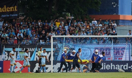 Penjaga gawang Persela Lamongan Choirul Huda ditandu petugas kesehatan ketika bertanding melawan Semen Padang dalam lanjutan Gojek Traveloka Liga 1 di Stadion Surajaya Lamongan, Jawa Timur, Ahad (15/10). 