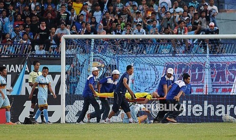 Penjaga gawang Persela Lamongan Choirul Huda ditandu petugas kesehatan ketika bertanding melawan Semen Padang dalam lanjutan Gojek Traveloka Liga 1 di Stadion Surajaya Lamongan, Jawa Timur, Minggu (15/10). 