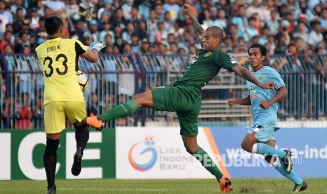 Penjaga gawang Persela Lamongan Dwi Kuswanto (kiri) berusaha menghentikan laju dari pesepak bola Persebaya Surabaya David Aprecido Da Silva (tengah) dalam kompetisi Go-Jek Liga 1 di Stadion Surajaya Lamongan, Jawa Timur, Jumat (30/3). Kedua tim bermain imbang dengan skor 1-1. 