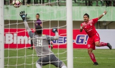 Penjaga gawang PSMS Medan Dhika Bayangkara (kiri) berusaha menghalau tendangan pemain Persija Jakarta Bambang Pamungkas (kanan) pada pertandingan leg kedua semifinal Piala Presiden 2018 di Stadion Manahan, Solo, Jawa Tengah, Senin (12/2). Pada pertandingan tersebut Persija Jakarta menang dengan skor 1-0 dan berhasil lolos ke Final dengan keunggulan agregat (5-1). 