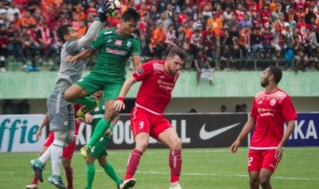 Penjaga gawang PSMS Medan Dhika Bayangkara (kiri) menangkap bola umpan pemain Persija Jakarta pada pertandingan Semi Final Leg-2 Piala Presiden 2018 di Stadion Manahan, Solo, Jawa Tengah, Senin (12/2). Pada pertandingan tersebut Persija Jakarta menang dengan skor 1-0 dan berhasil lolos ke Final dengan keunggulan agregat (5-1). 