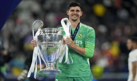 Penjaga gawang Real Madrid Thibaut Courtois berpose dengan trofi setelah memenangkan pertandingan sepak bola final Liga Champions antara Liverpool dan Real Madrid di Stade de France di Saint Denis dekat Paris, Ahad, 29 Mei 2022. Real Madrid mengalahkan Liverpool 1-0.