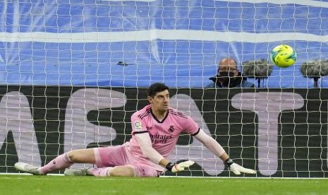 Penjaga gawang Real Madrid Thibaut Courtois melakukan penyelamatan selama pertandingan sepak bola La Liga Spanyol antara Rial Madrid dan FC Barcelona di stadion Santiago Bernabeu di Madrid, Spanyol, Senin (21/3/2022).