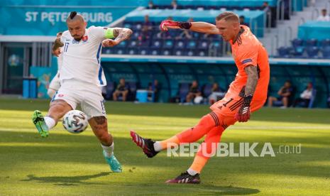 Penjaga gawang Swedia Robin Olsen menendang bola ketika pemain Slovakia Marek Hamsik mencoba menghentikannya, selama pertandingan grup E kejuaraan sepak bola Euro 2020 antara Swedia dan Slovakia, di stadion Saint Petersburg, di Saint Petersburg, Rusia,  Jumat (18/6).