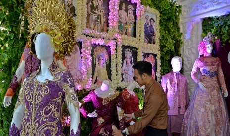 Penjaga stan menata busana pengantin kontemporer pada ajang Wedding Expo di Semarang, Jawa Tengah, Kamis (13/4).