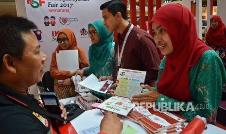 Penjaga stan Otoritas Jasa Keuangan (OJK) mengedukasi seorang pengunjung tentang berbagai produk perbankan syariah pada Keuangan Syariah Fair (KSF) 2017, di Semarang, Jawa Tengah, Jumat (12/5). KSF yang diikuti 40 pelaku industri jasa keuangan syariah, terdiri dari 19 industri keuangan non bank syariah, 13 bank syariah, serta delapan manajer investasi dan perusahaan sekuritas.