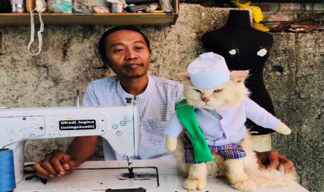 Penjahit Fredi Lugina Priadi menunjukkan kostum baju kucing di kediamannya.