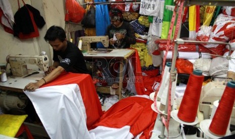 Penjahit menyelesaikan pesanan bendera merah putih di Blok V Pasar Senen, Jakarta, Rabu (6/8).( Republika/Yasin Habibi)