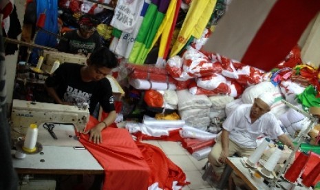 Penjahit menyelesaikan pesanan bendera merah putih di Blok V Pasar Senen, Jakarta