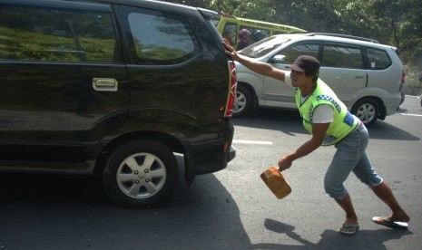 Penjaja jasa ganjal ban mobil mendorong kendaraan pemudik / Ilustrasi