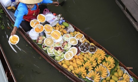 Penjaja kuliner dan buah di pasar tradisional di Thailand.