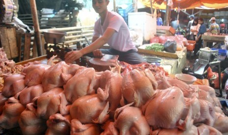 Penjual ayam potong melayani pembeli di pasar tradisional Leuwiliang, Kabupaten Bogor, Jawa Barat, Selasa (17/7).