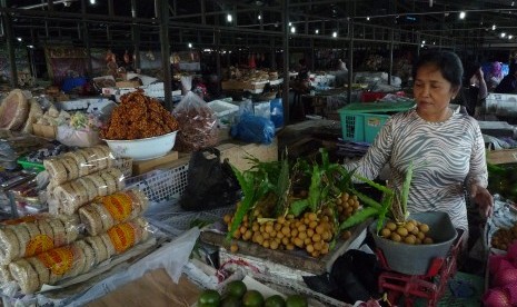 Penjual buah menimbang buah lengkeng di lokasi penampungan sementara pedagang Pasar Klewer di Solo, Jawa Tengah, Minggu (23/4).