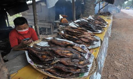 Penjual ikan salai menanti pembeli di Jalan Musi II, Kota Palembang, Provini Sumsel, Senin (15/2/2021). 