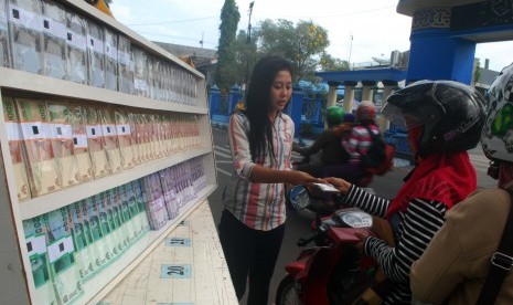 Penjual jasa penukaran uang melayani penukaran uang baru di depan Masjid Baitul Hakim, Kota Madiun, Jawa Timur. (ilustrasi)